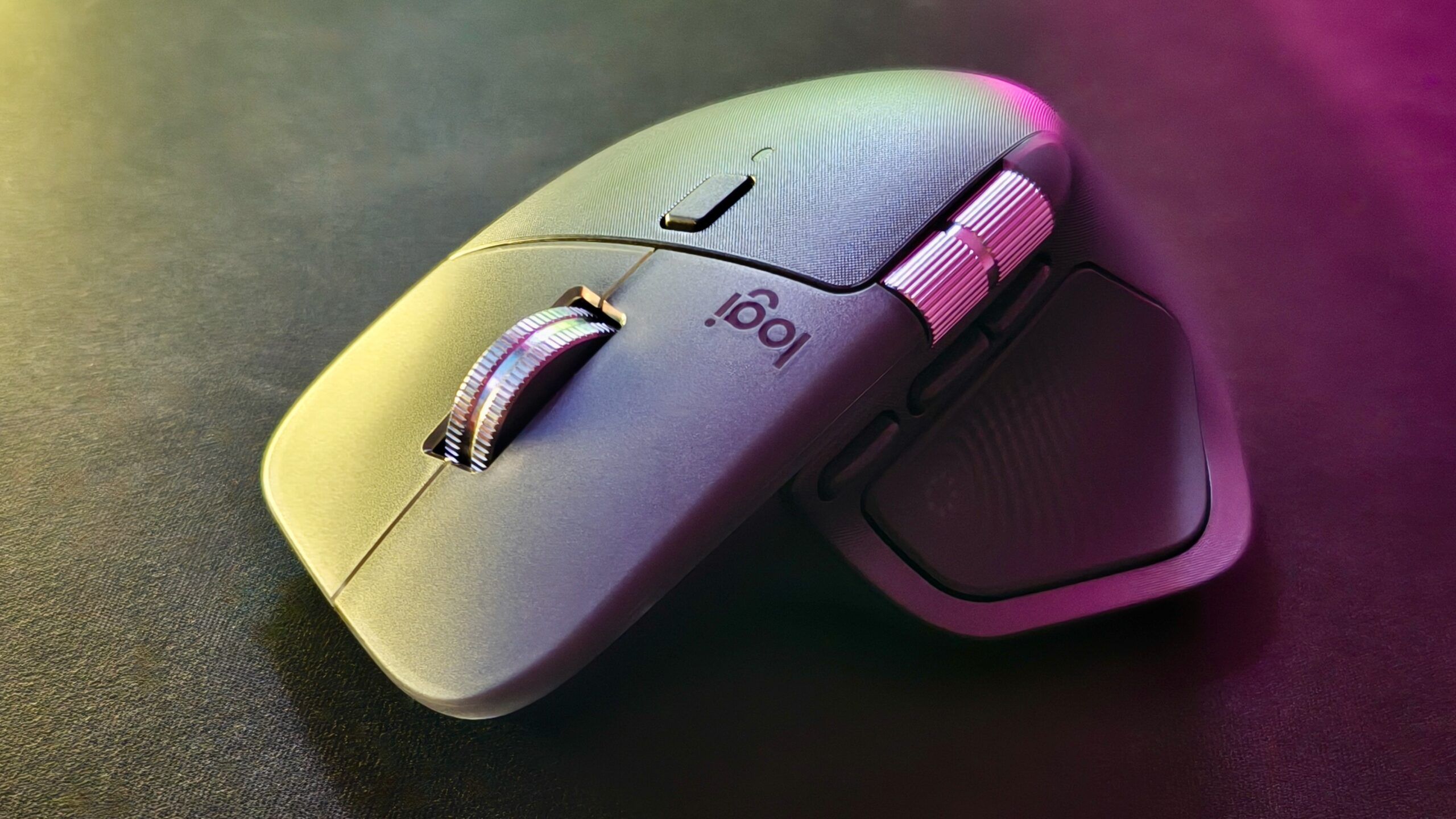 Logitech MX Master 4 na ciemnym biurku, widok z góry pod kątem