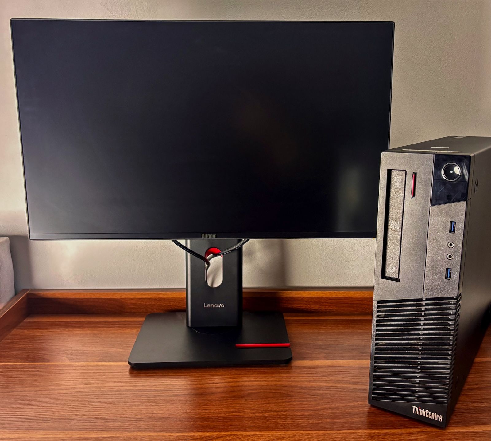 Monitor Lenovo ThinkVision T24-40 na biurku obok komputera stacjonarnego Lenovo ThinkCentre