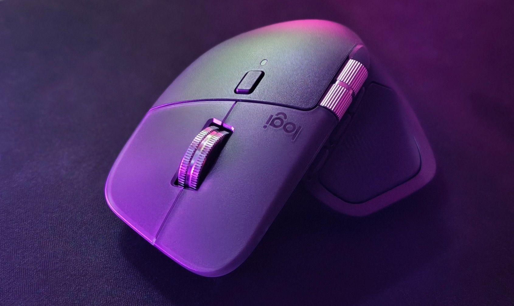 Ujęcie z góry na MX Master 4 w fioletowym oświetleniu, widoczny przycisk zmiany trybu kółka