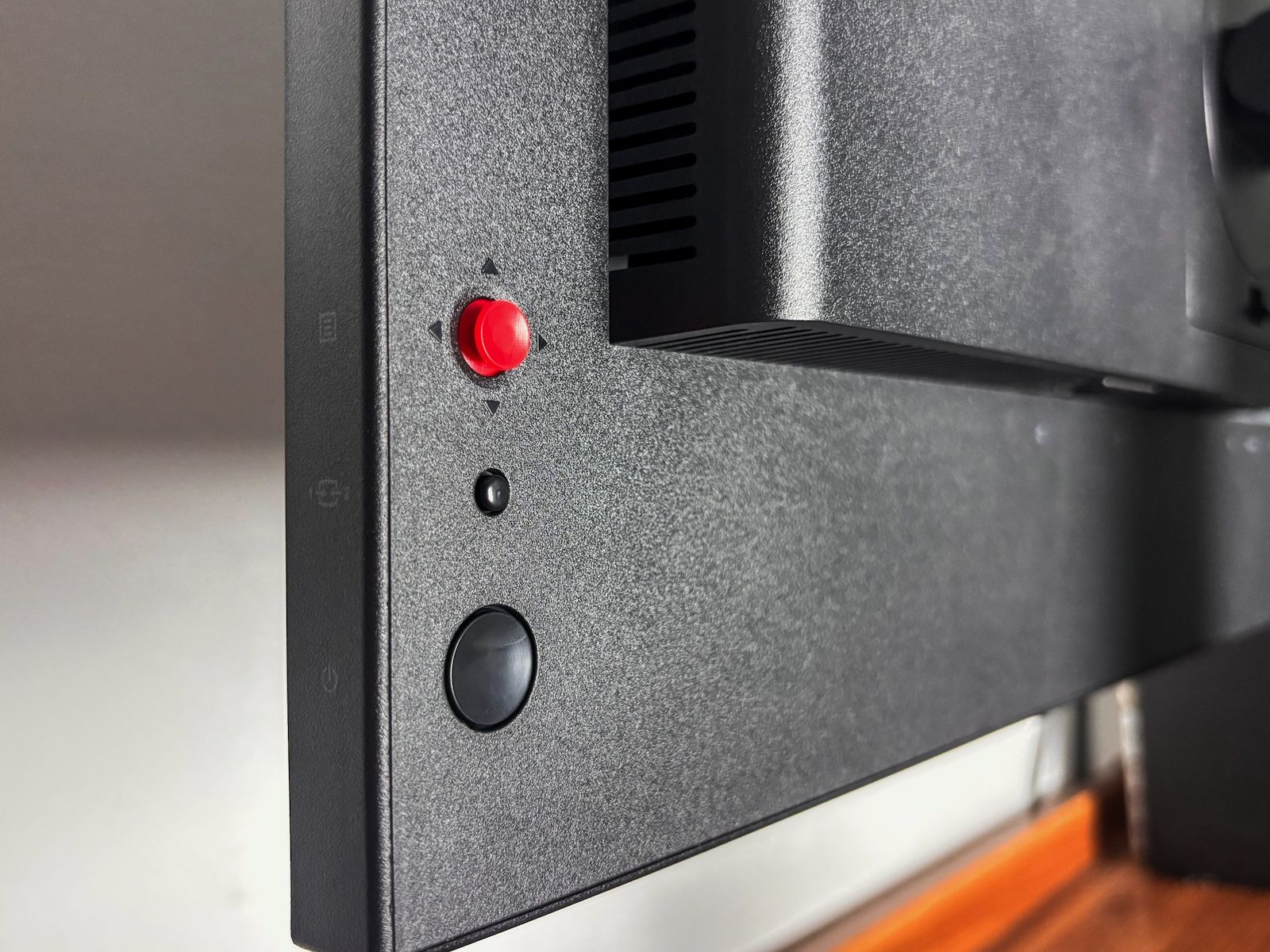 Zbliżenie na czerwony joystick do sterowania menu OSD i przycisk zasilania w monitorze Lenovo ThinkVision T24-40