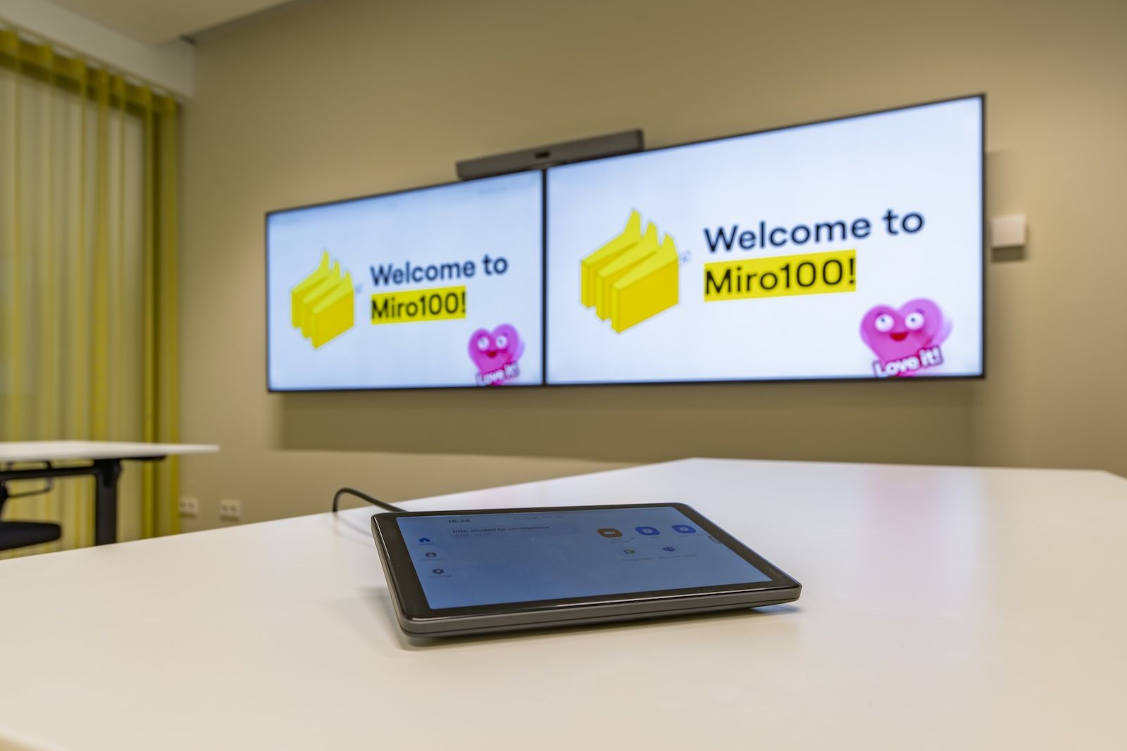 Panel sterowania do wideokonferencji i dwa ekrany Sony Bravia w nowoczesnej sali spotkań firmy Miro