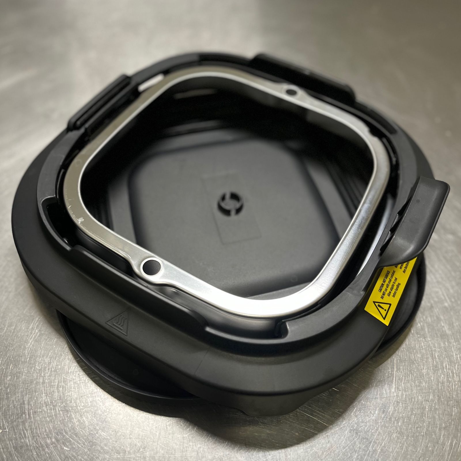 Metalowa płyta zapiekająca umieszczona wewnątrz plastikowego adaptera powiększającego z zestawu Ninja Crispi