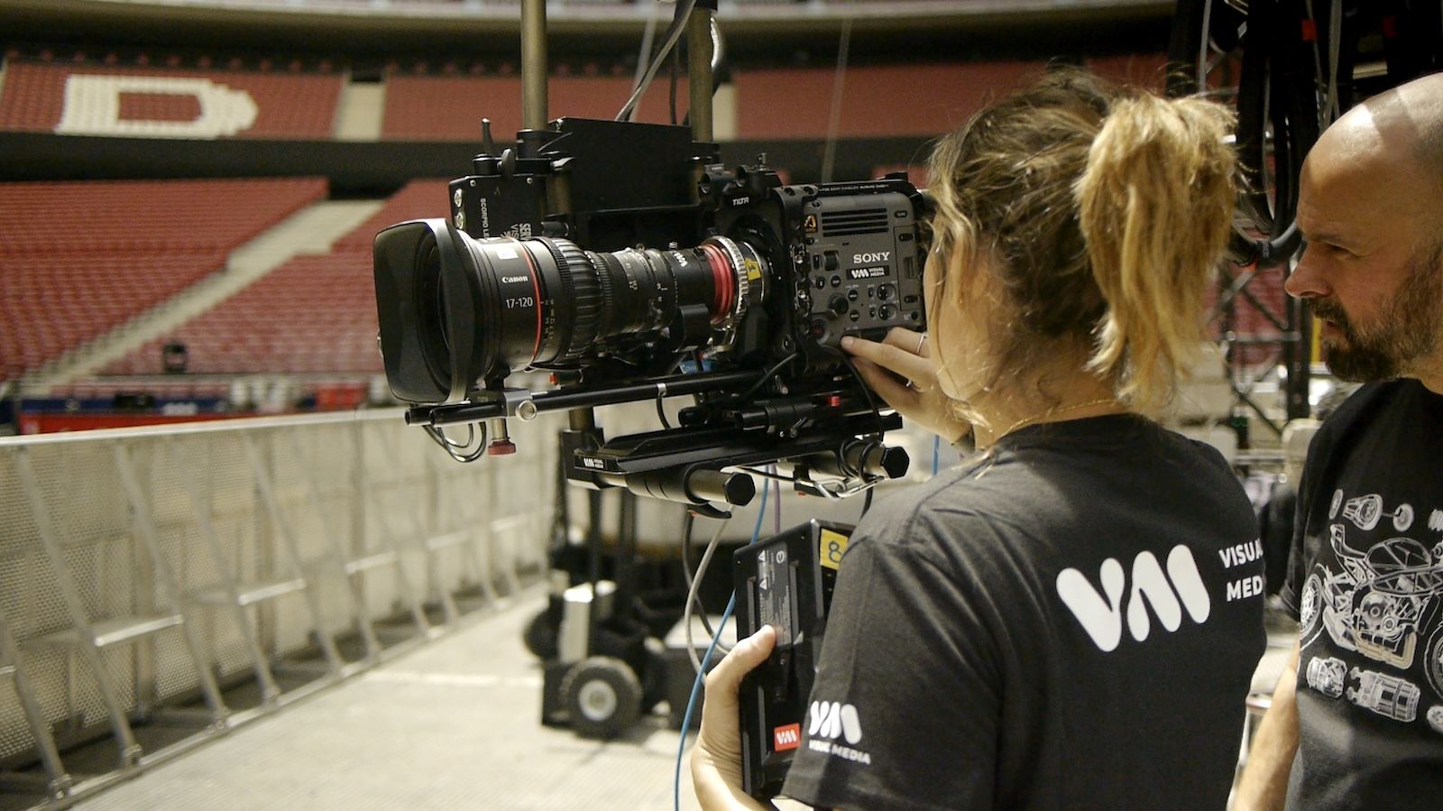 Operatorka firmy Visual Media przygotowująca kamerę kinową Sony z obiektywem Canon do transmisji na żywo na pustym stadionie