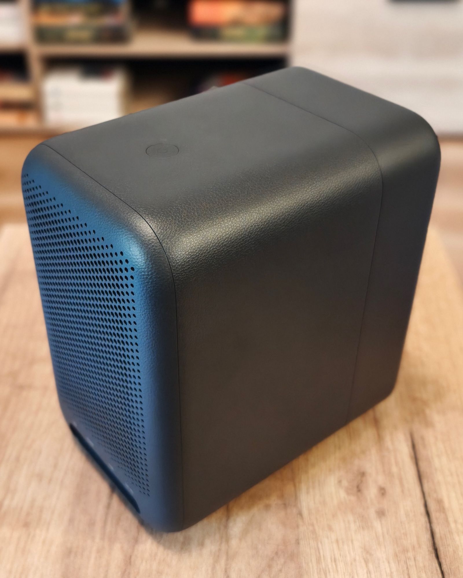 Widok z góry na obudowę projektora Xiaomi L1 Pro pokazujący przycisk zasilania oraz fakturę imitującą skórę