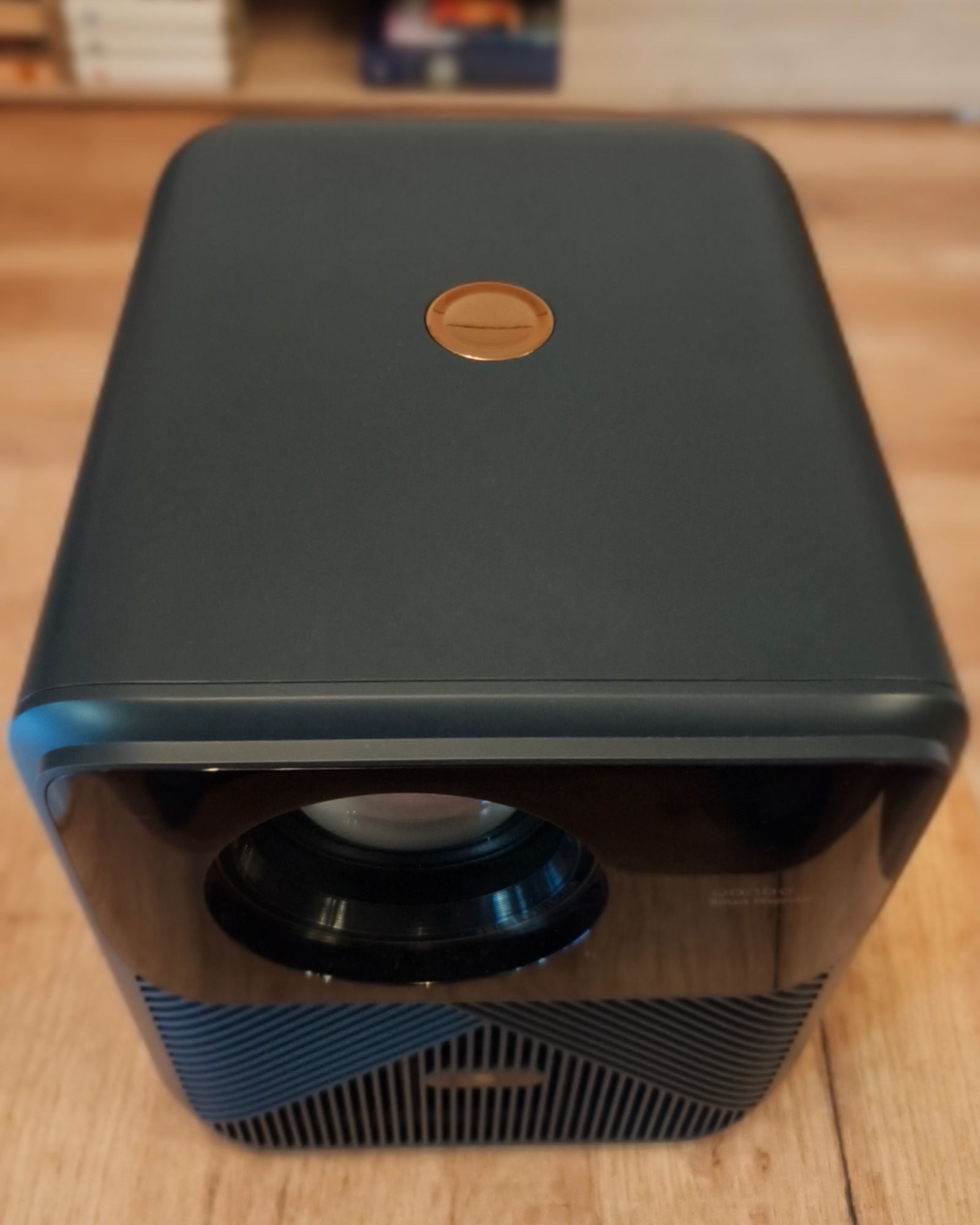 Widok z góry na projektor Wanbo Mozart 1 Pro z widocznym miedzianym przyciskiem zasilania