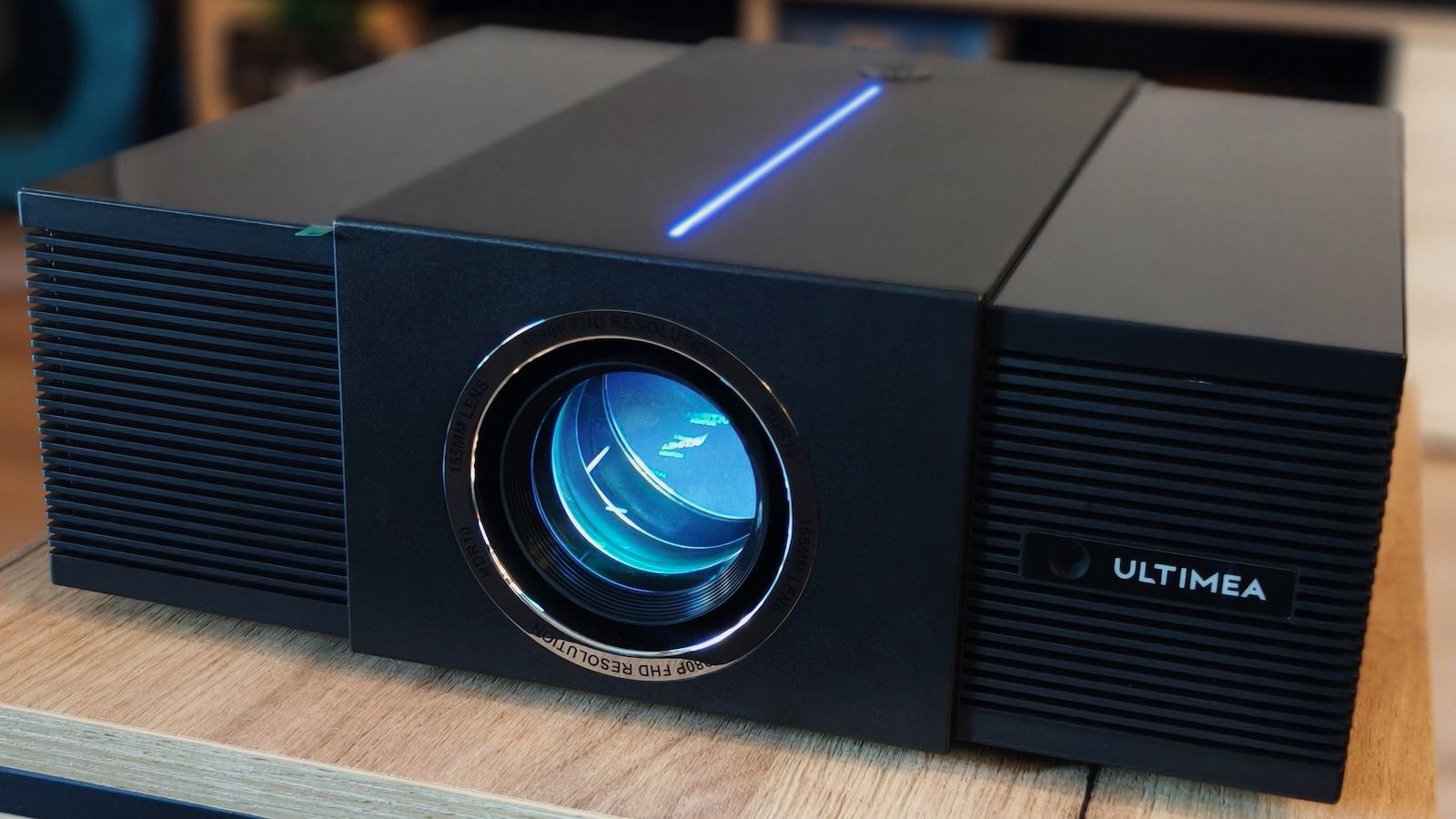 Włączony projektor Ultimea Apollo P60 z niebieskim światłem z obiektywu i diodą LED