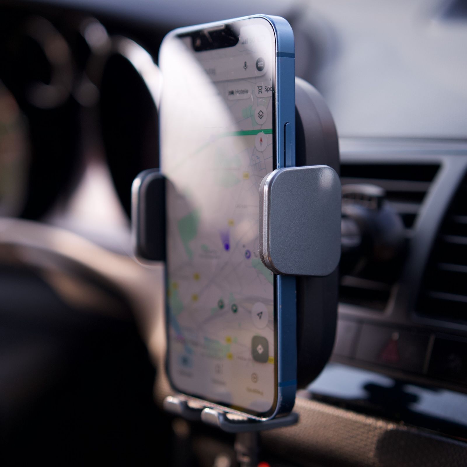 Widok z boku na elektryczny uchwyt Baseus LightChaser, mocno trzymający telefon z mapami Google