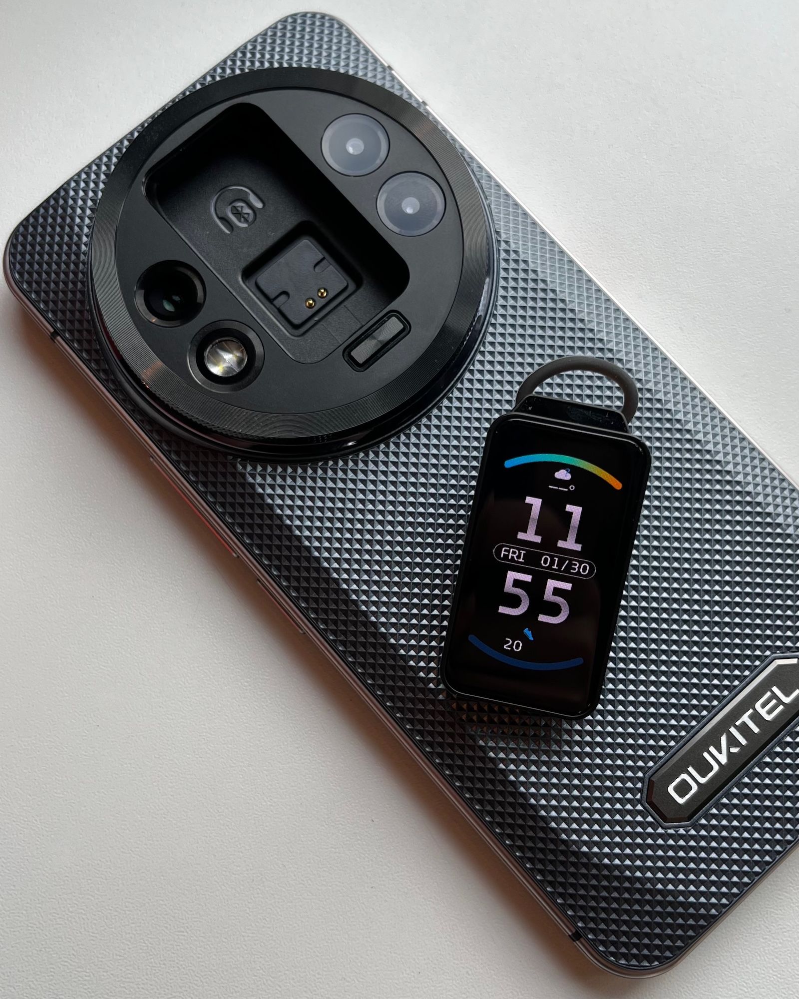 Wyciągnięty smartwatch i słuchawka leżący na tylnej obudowie telefonu Oukitel WP200 Pro