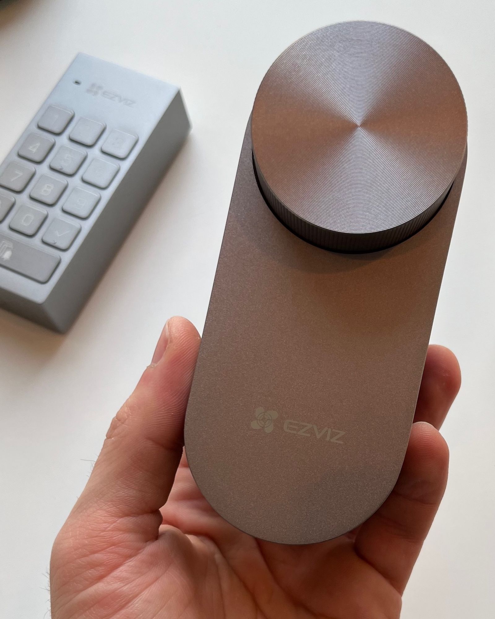 Zamek wewnętrzny EZVIZ DL01 Pro trzymany w dłoni, z widocznym masywnym pokrętłem