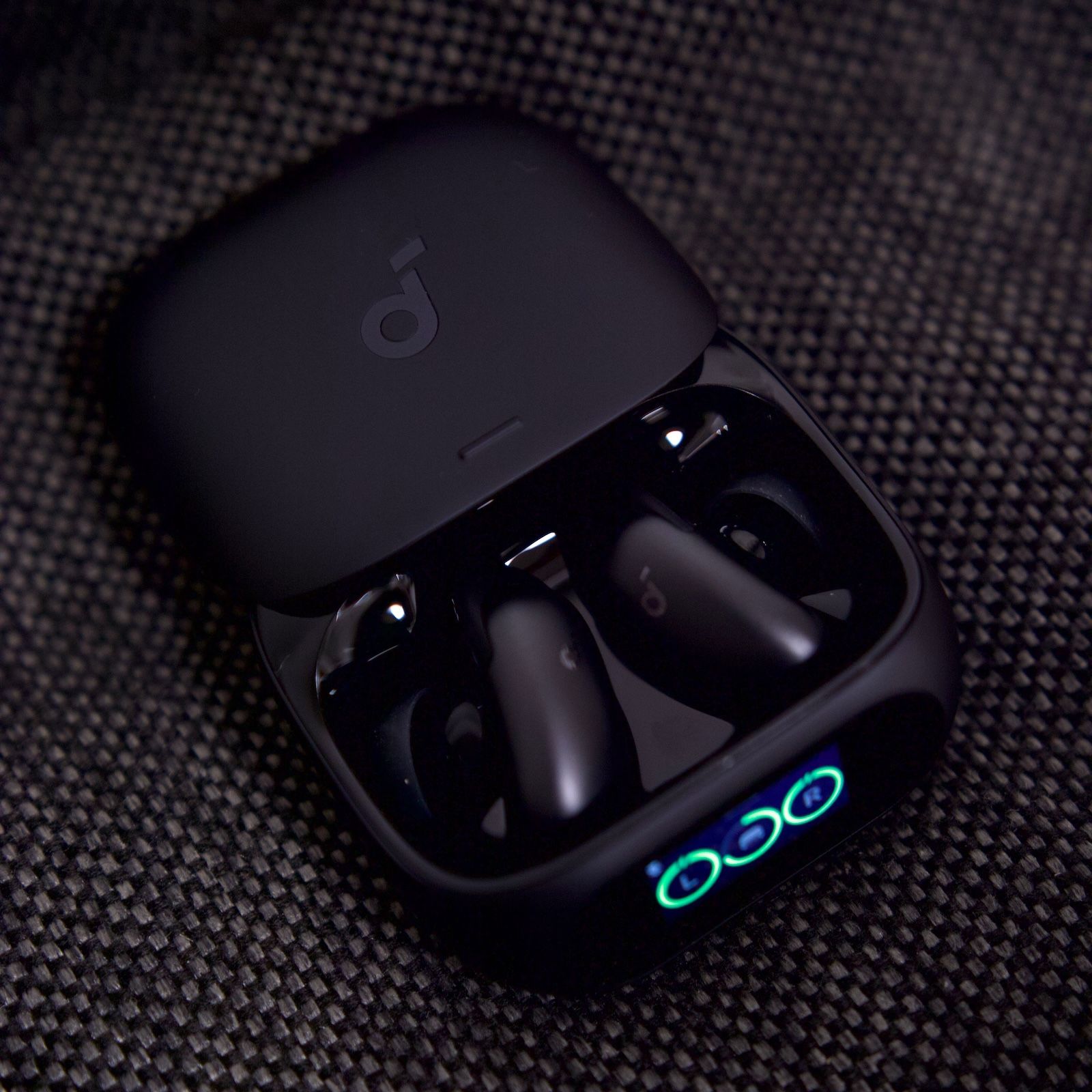Otwarte etui ładujące Soundcore Liberty 5 Pro z umieszczonymi wewnątrz słuchawkami, prezentujące podświetlony wskaźnik naładowania L i R