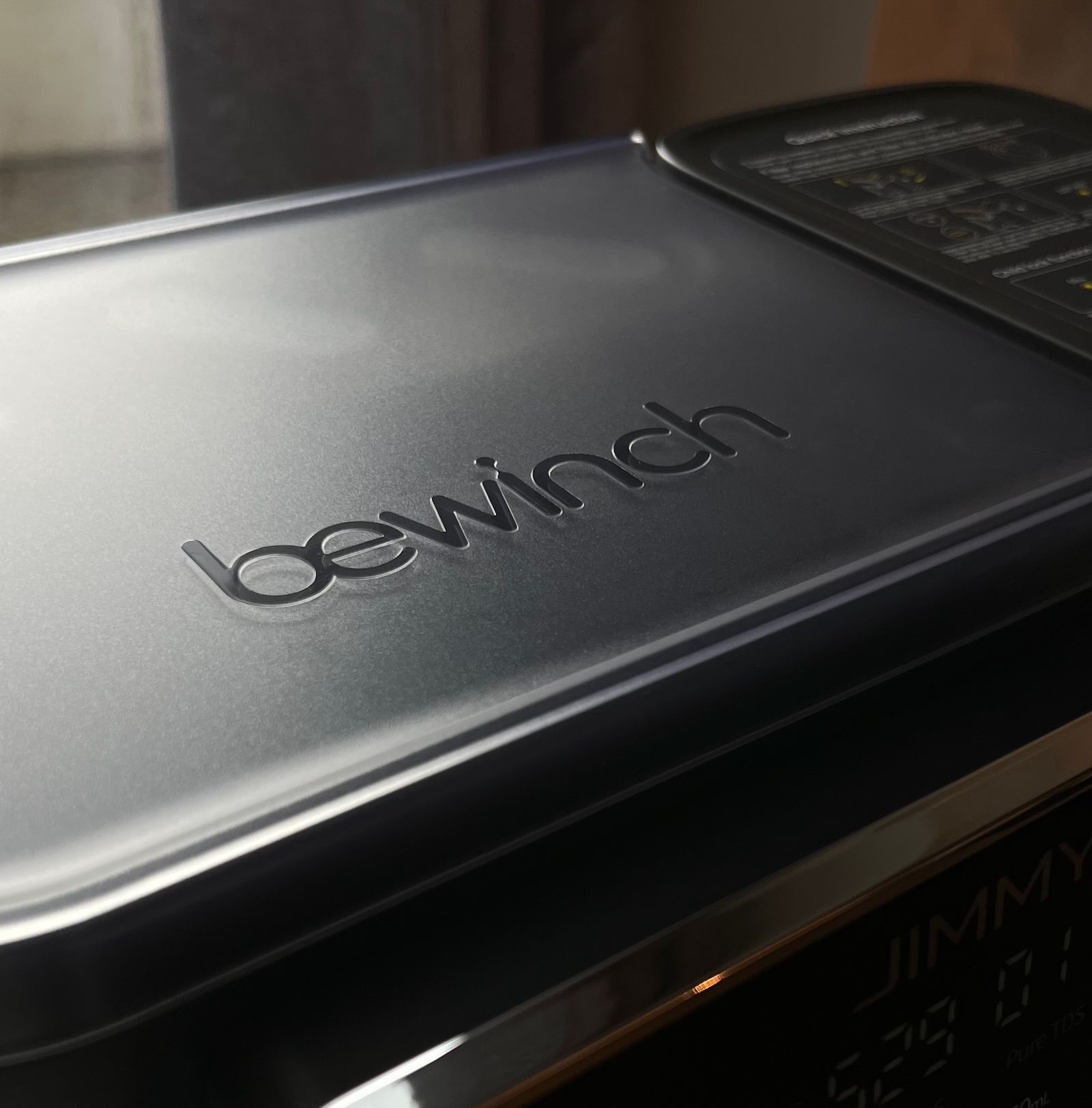 Zbliżenie na matową górną pokrywę urządzenia z tłoczonym logo bewinch
