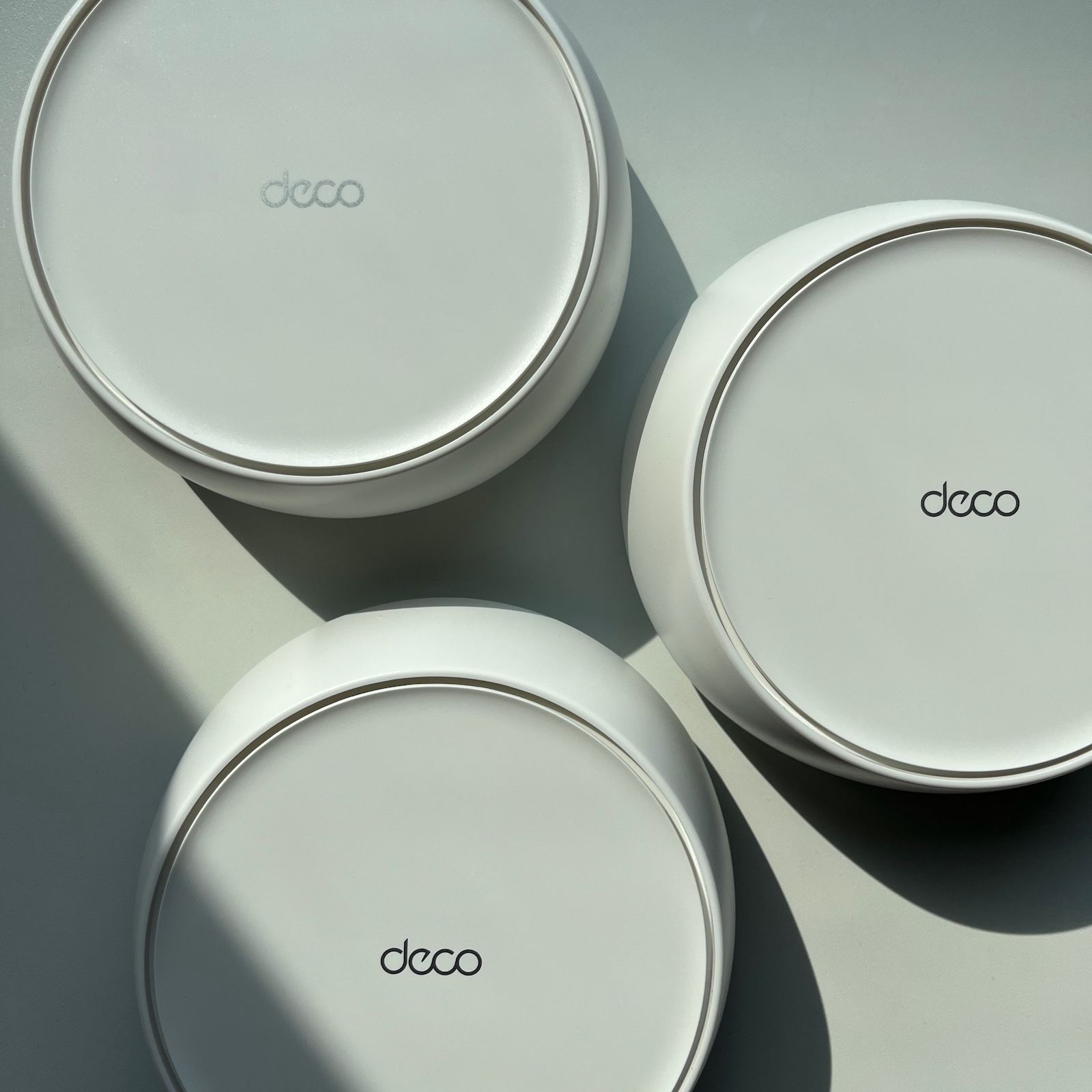 Trzy urządzenia TP-Link Deco widziane z góry