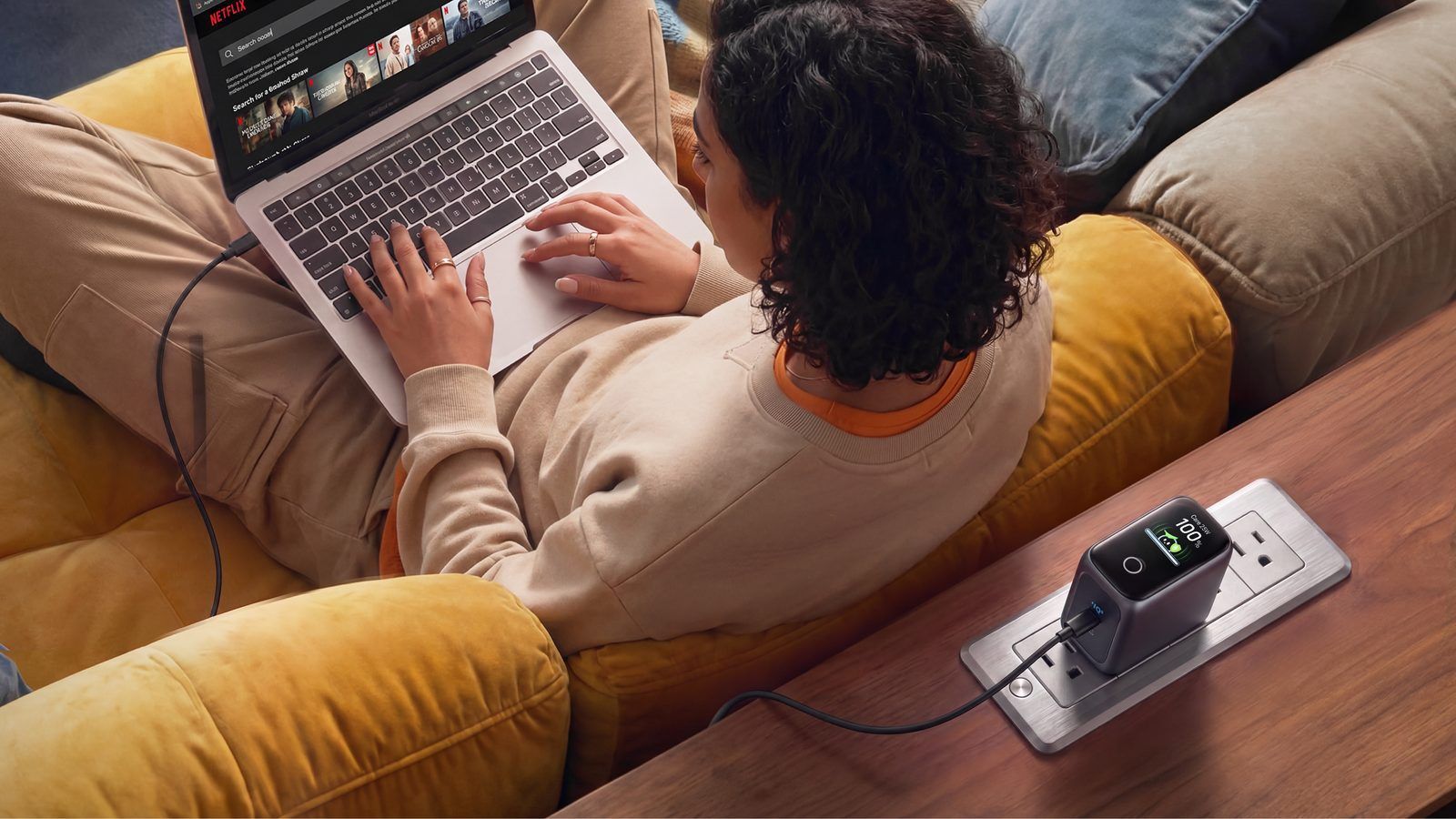 Kobieta ładująca laptopa za pomocą ładowarki Anker