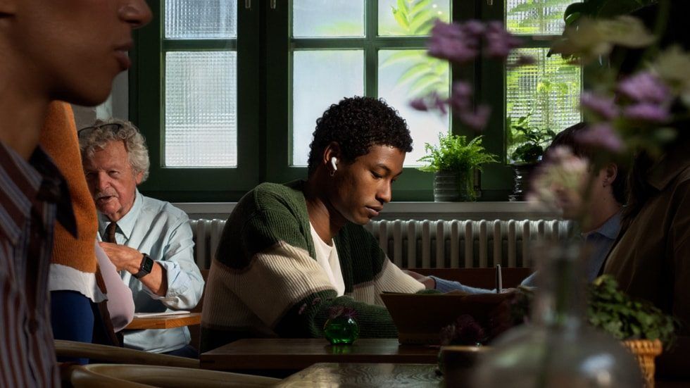 Młody mężczyzna z Apple AirPods 5 w restauracji