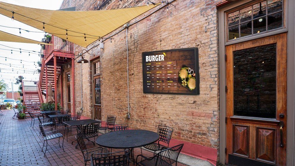 Ekran Newline XRT w zewnętrznym ogródku restauracyjnym