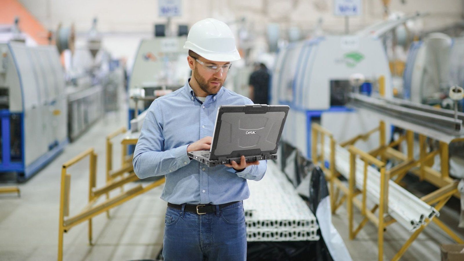 Specjalista w hali produkcyjnej obsługujący laptop Getac B360X